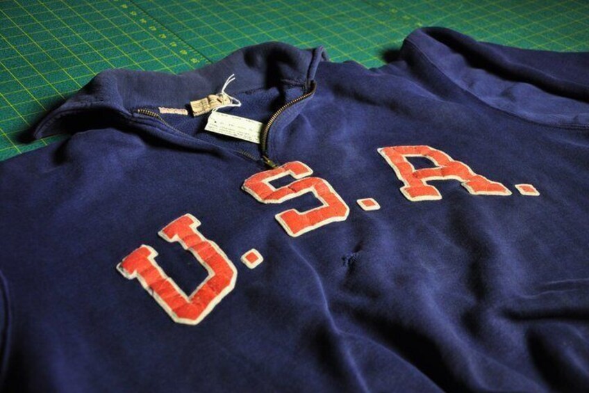 A dark blue garment with 'U.S.A.' embroidered in red letters. 1