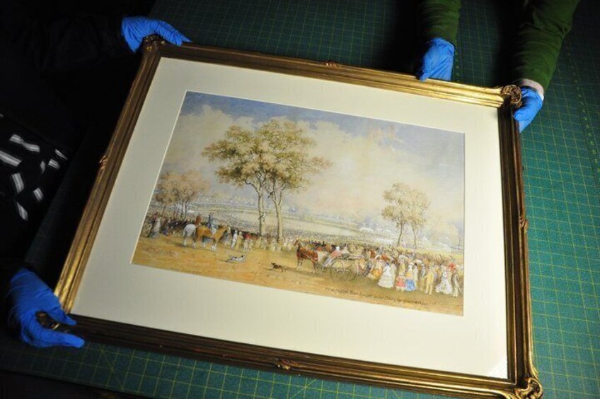 A framed artwork of a historical scene with people and trees. 3
