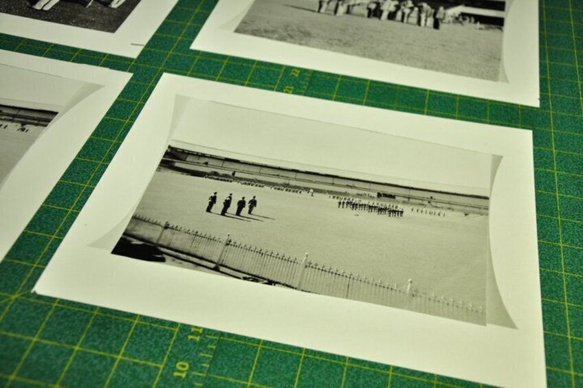 A photograph of a beach scene with people and a fence. 2