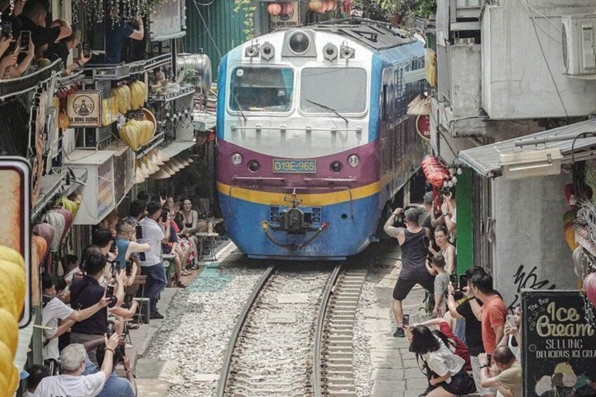 A train on tracks with people gathered around. 2