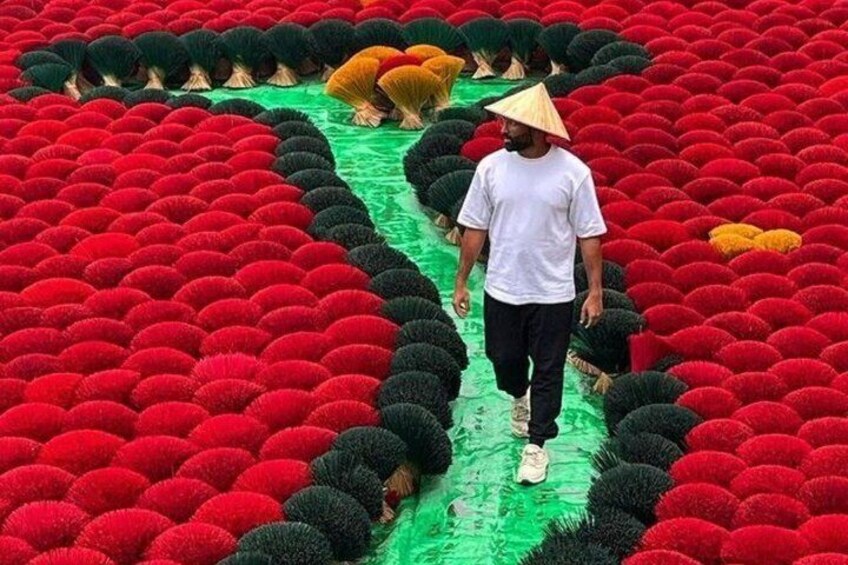 A person walking through a field of red and black spherical objects. 2