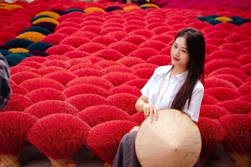 A person sitting among red and yellow patterned mats. 4