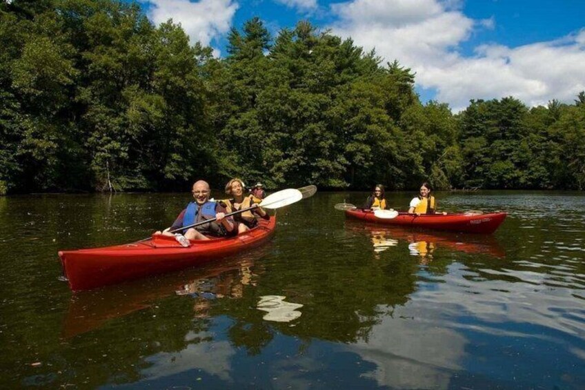 Two red canoes on a calm lake surrounded by dense trees. 1