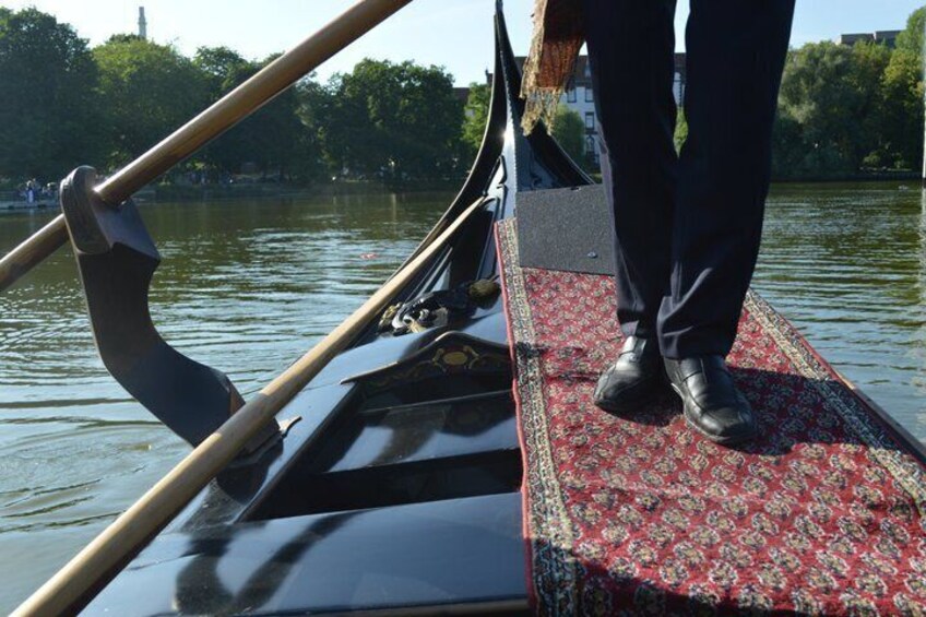 A gondola on water with a person standing at the stern. 5