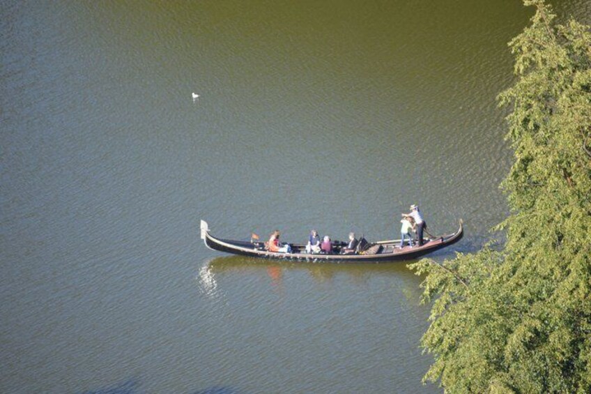 A longboat with passengers on a calm lake surrounded by greenery. 3