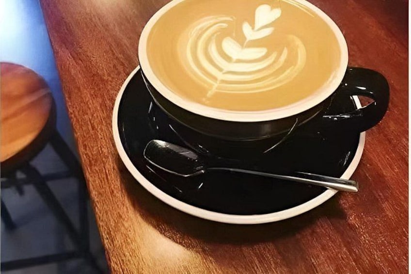 A cup of coffee with latte art on a saucer. 3