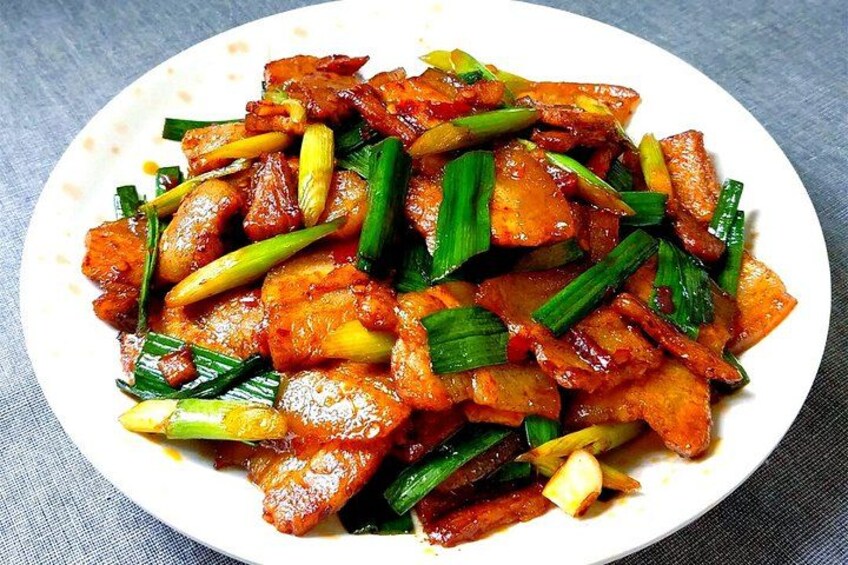 A plate of stir-fried meat with vegetables. 5