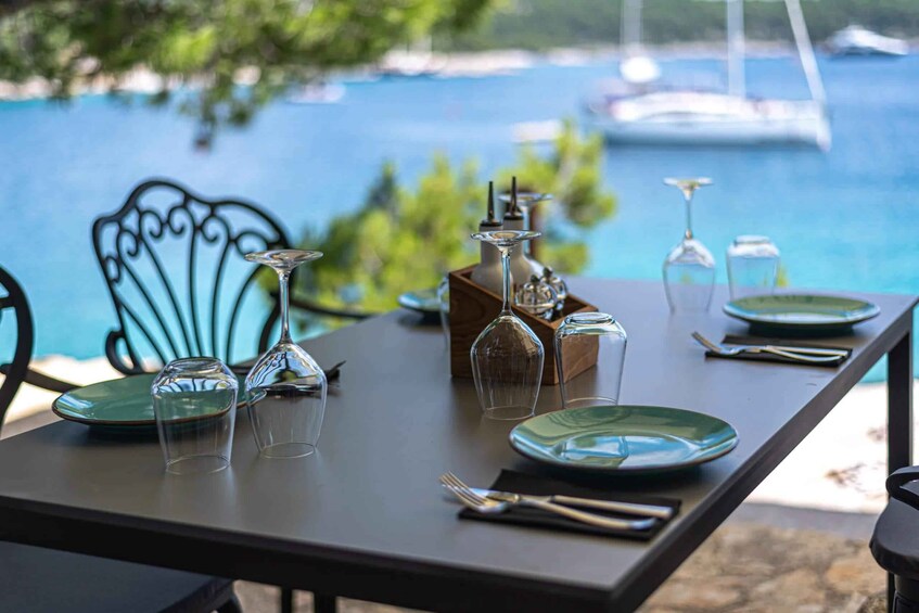A table set for dining with a view of the sea and boats in the background. 4