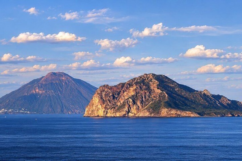 A coastal landscape with a prominent mountain and a smaller hill in the foreground. 5