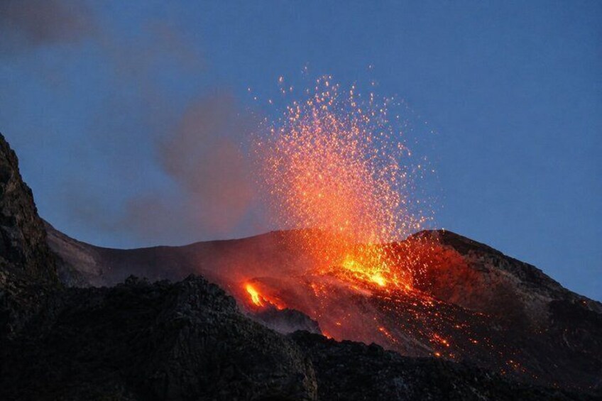 A volcanic eruption with lava flowing down the side of a mountain. 2