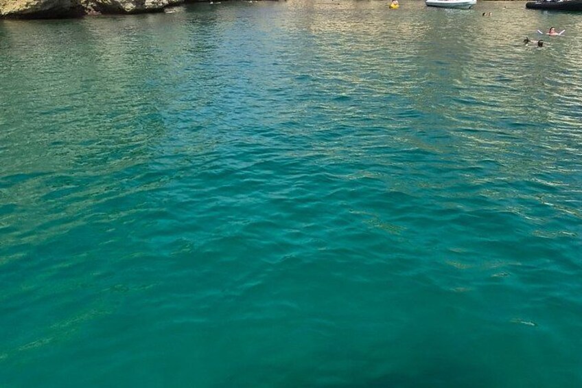 A turquoise body of water with a rocky shoreline. 5