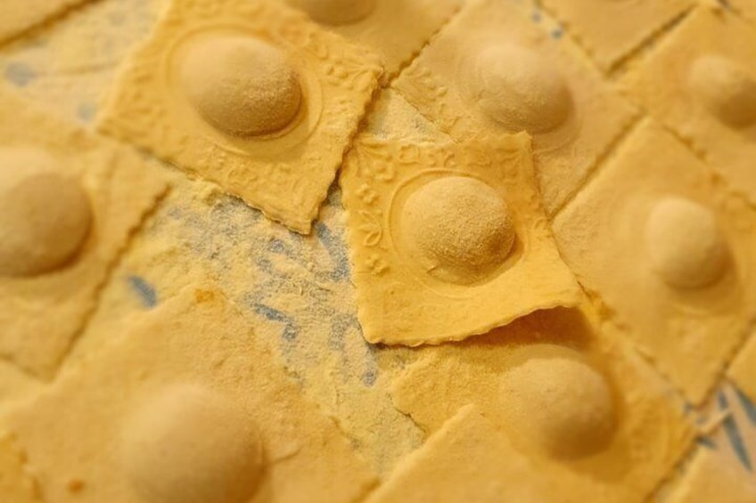 A close-up of ravioli pasta with a dusting of flour. 1