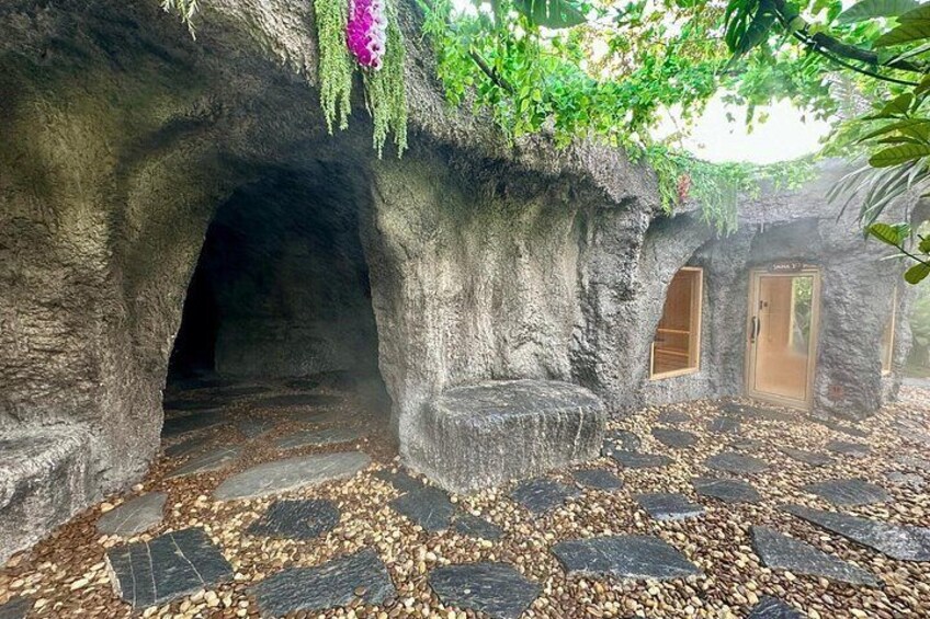 A cave-like structure with a wooden door, a stone pathway, and a natural cave entrance. 4
