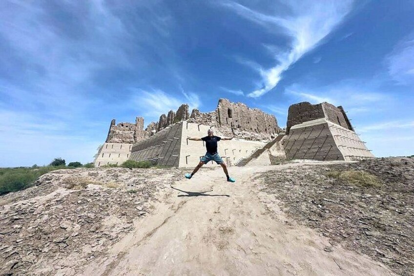 A person running on a dirt path with ancient ruins in the background. 3