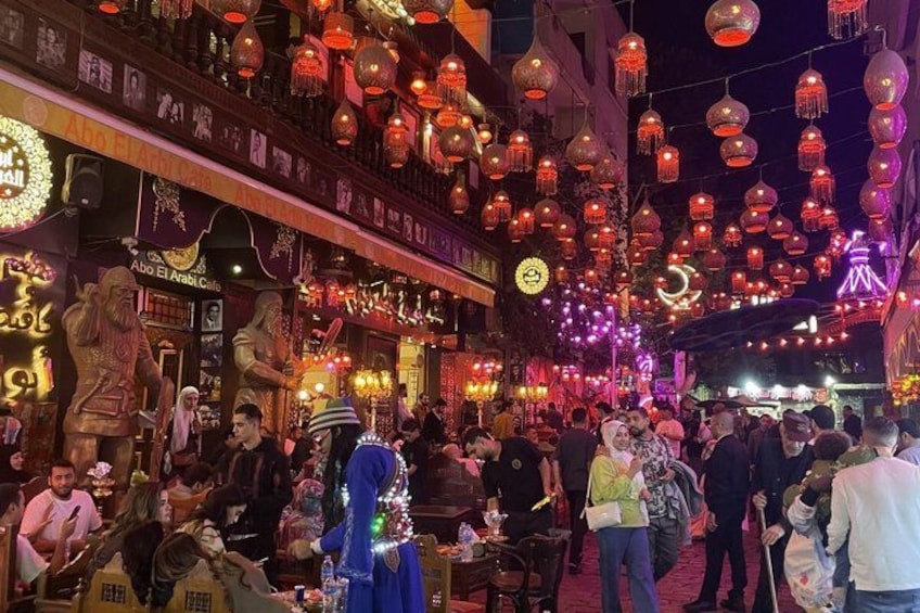 A crowded street with traditional lanterns and statues. 2