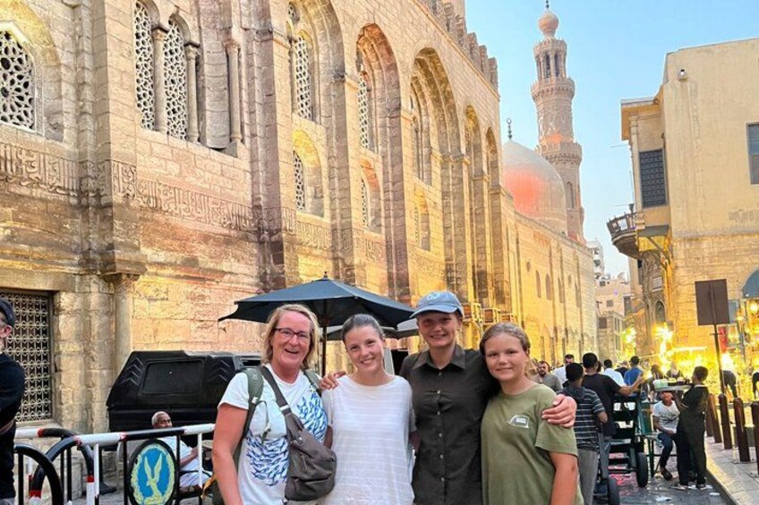 A group of people posing in front of a historic building with intricate architecture. 4