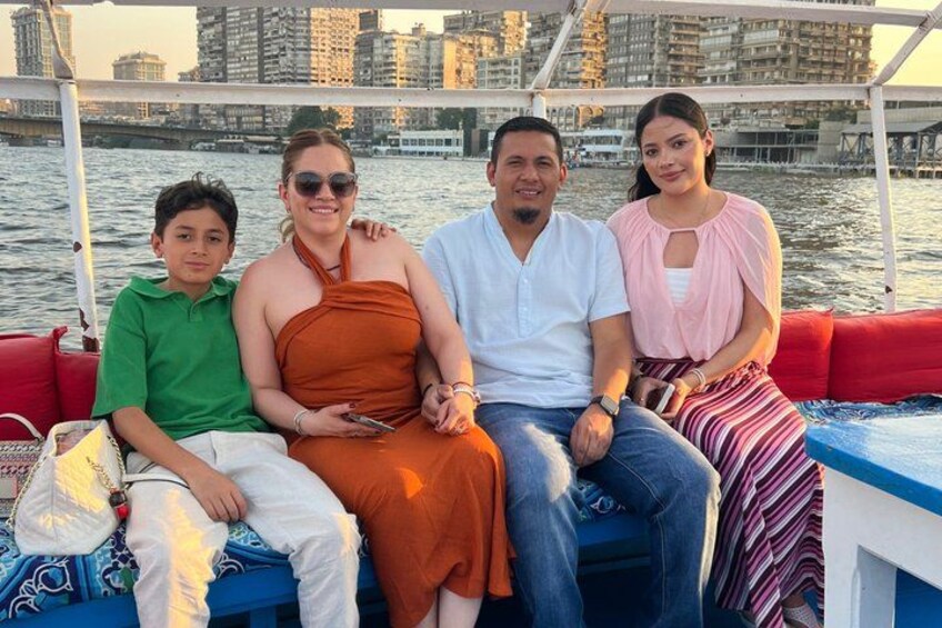 A group of people on a boat with a cityscape in the background. 3