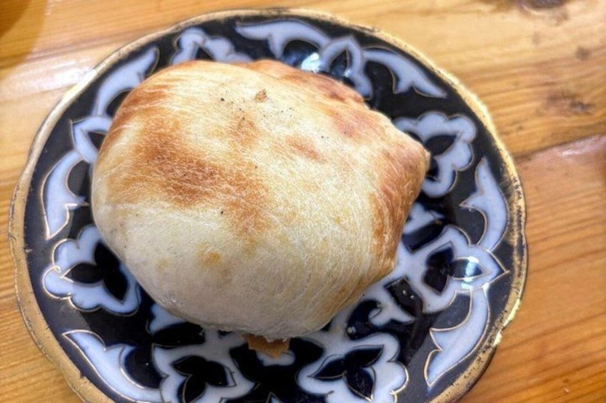 A round pastry on a decorative plate. 4