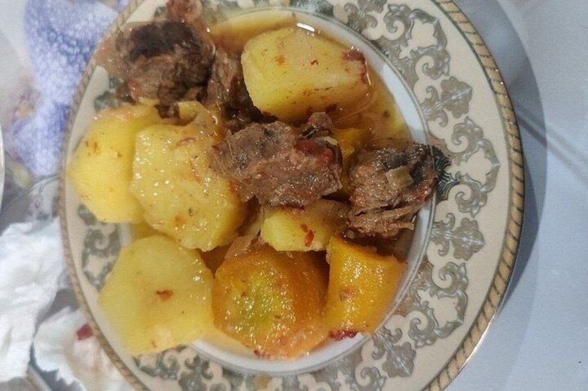 A plate of beef stew with potatoes. 2