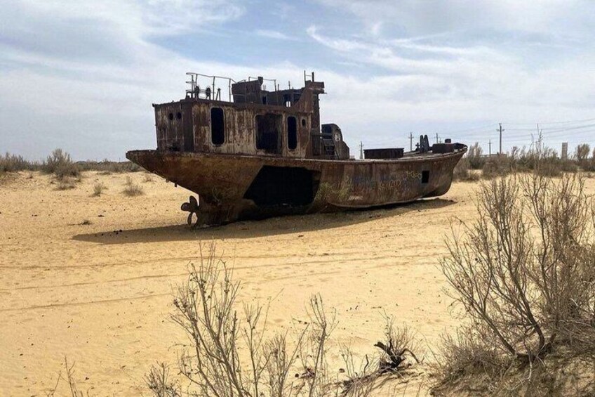 A rusted shipwreck in a desert landscape. 3