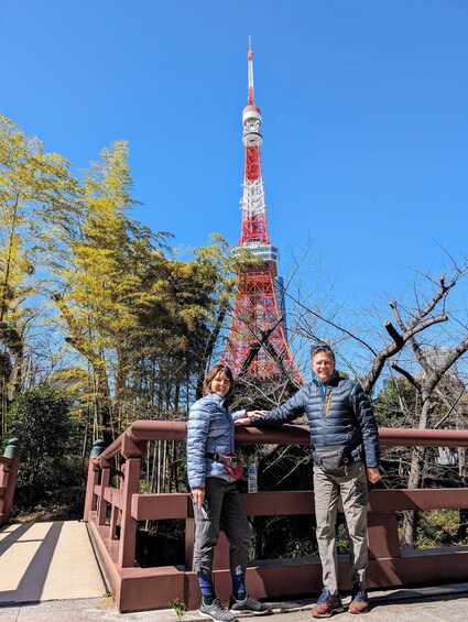 Two people standing on a bridge with the Tokyo Tower in the background. 2