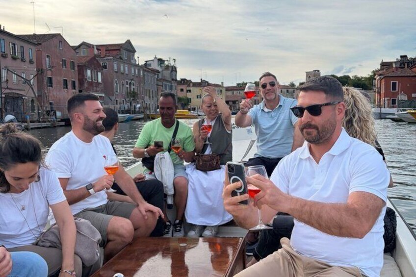 A group of people on a boat in a canal with buildings in the background. 3