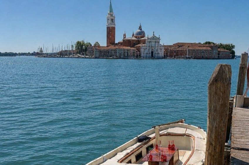 A boat docked at a pier with a historic building in the background. 1