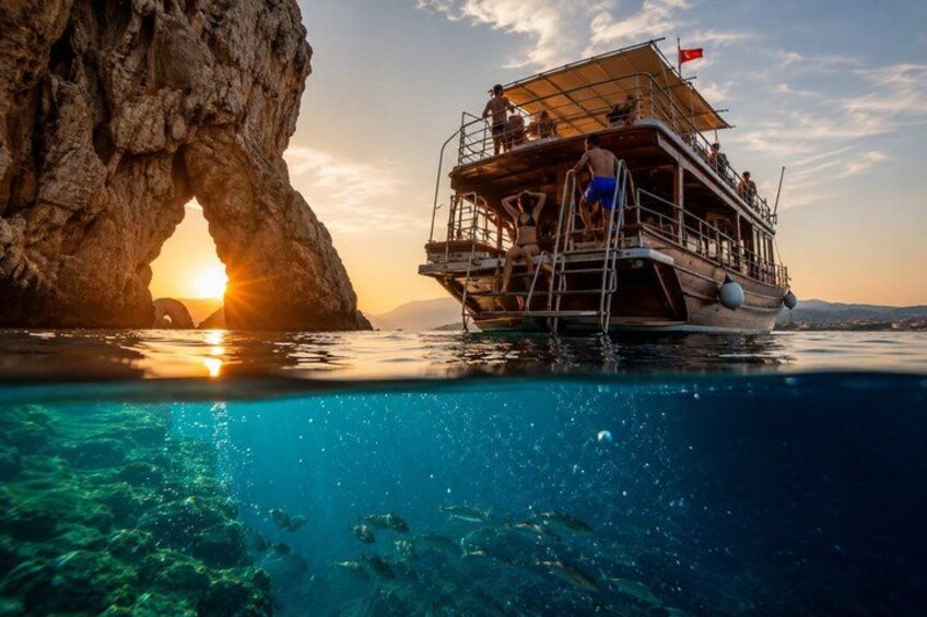 A boat with passengers, a rocky arch formation, and a sunset. 5