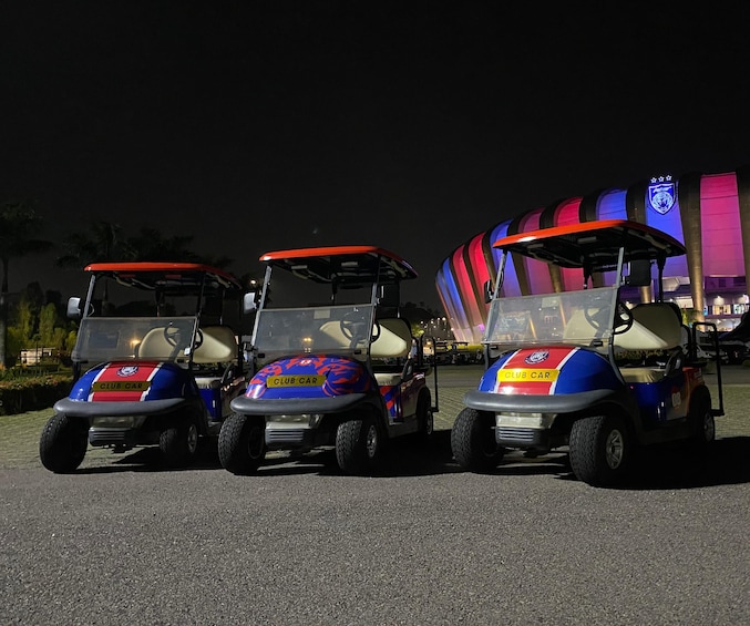 Three golf carts parked on a road at night. 1