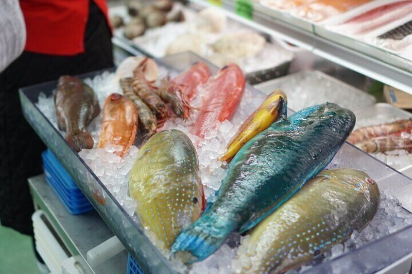 A variety of fresh seafood on ice in a market display. 2