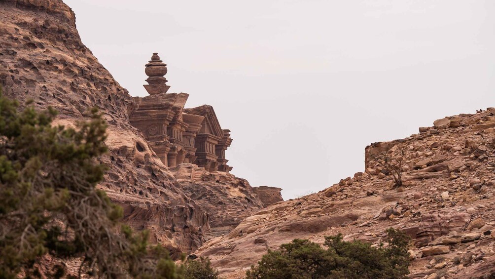 A rock formation with a small, ancient structure. 5