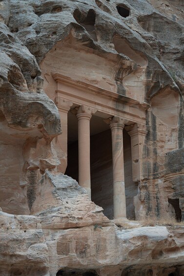 A rock-cut temple with columns and a central opening. 2