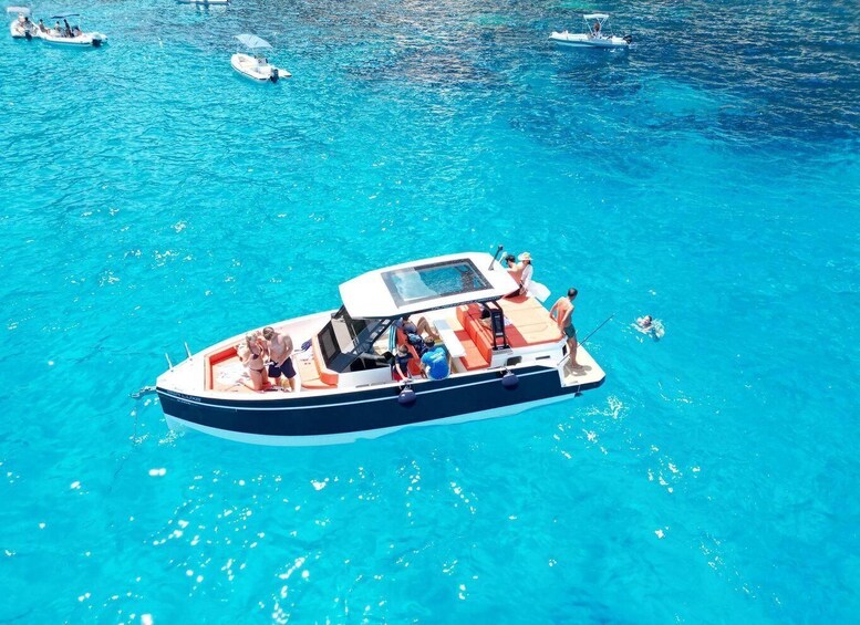 A small motorboat with passengers on a clear blue sea. 4