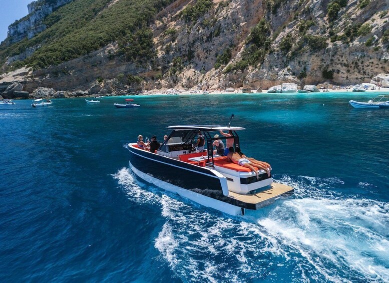 A boat on a clear blue sea with rocky cliffs in the background. 5