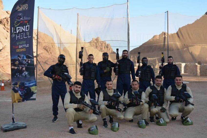 A group of armed personnel in a desert setting with a banner reading 'Island of Hell.' 1