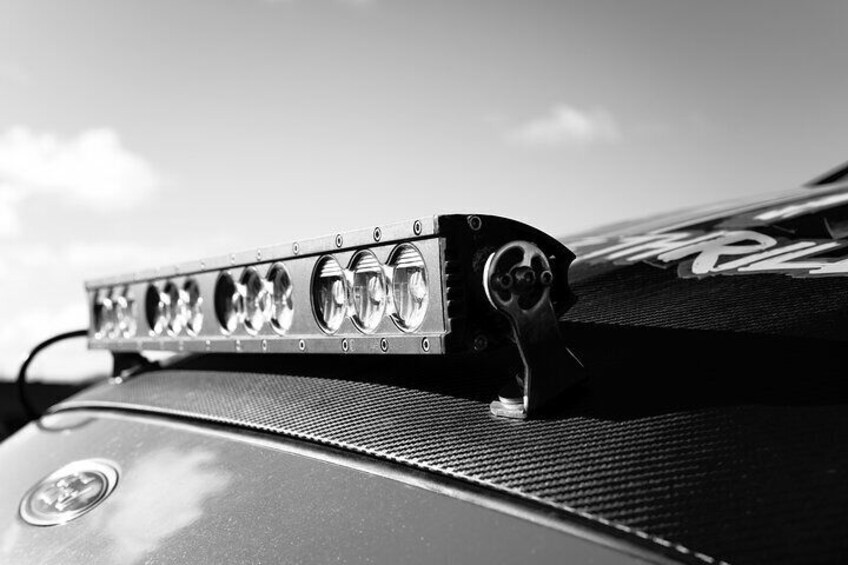 A close-up of a car's roof rack with multiple lights and a logo. 2