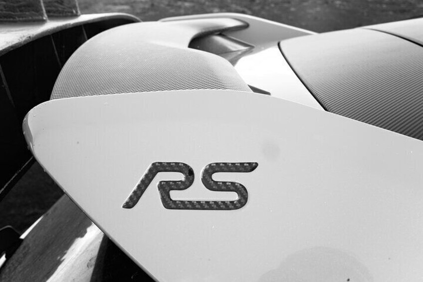 A car's interior with the logo 'RS' on the steering wheel cover. 3