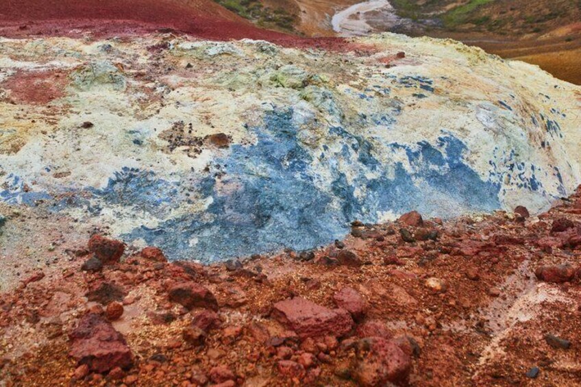 A colorful geological formation with red, white, and blue hues. 3