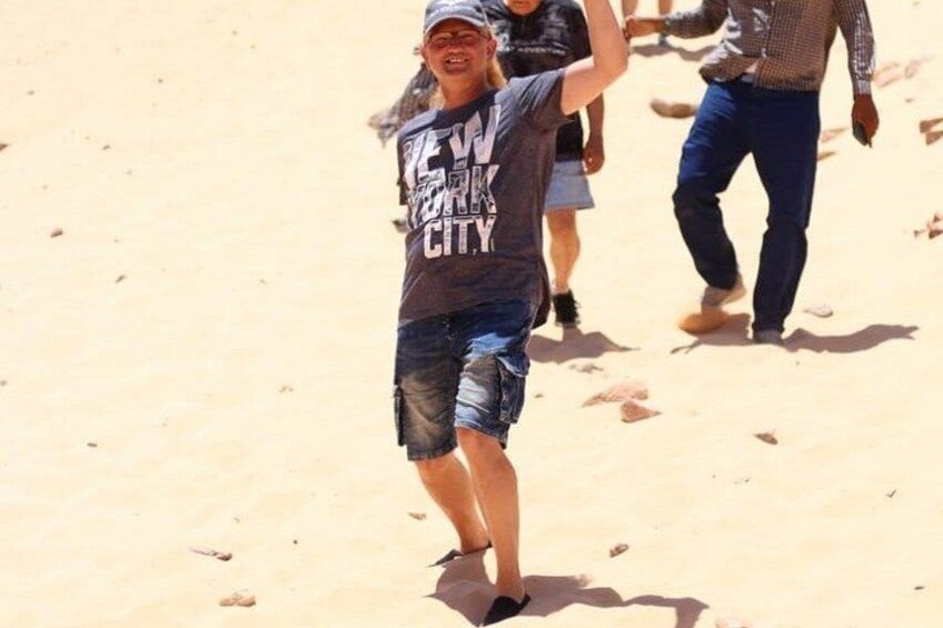 A person walking on a sandy beach with footprints. 5