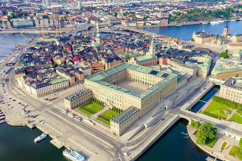 An aerial view of a city with a prominent historical building complex, a river, and a bridge. 3