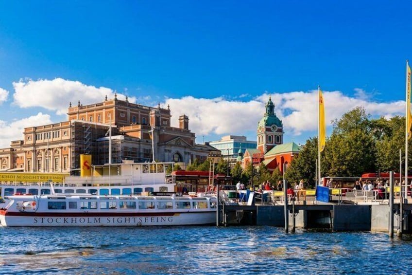 A boat named 'Stockholm Sightseeing' docked at a pier with historic buildings in the background. 5