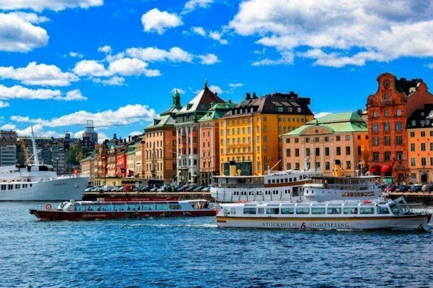 A waterfront with colorful buildings and two boats, one labeled 'Stockholm Sightseeing.' 4