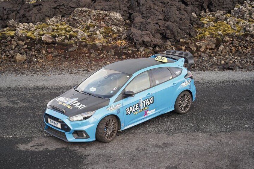 A blue race taxi with 'RACE TAXI' and 'SPIRIT' on the front. 1