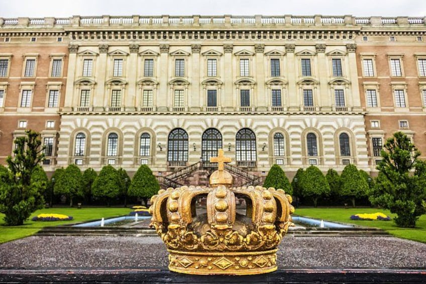 A grand building with a large golden crown in the foreground. 3