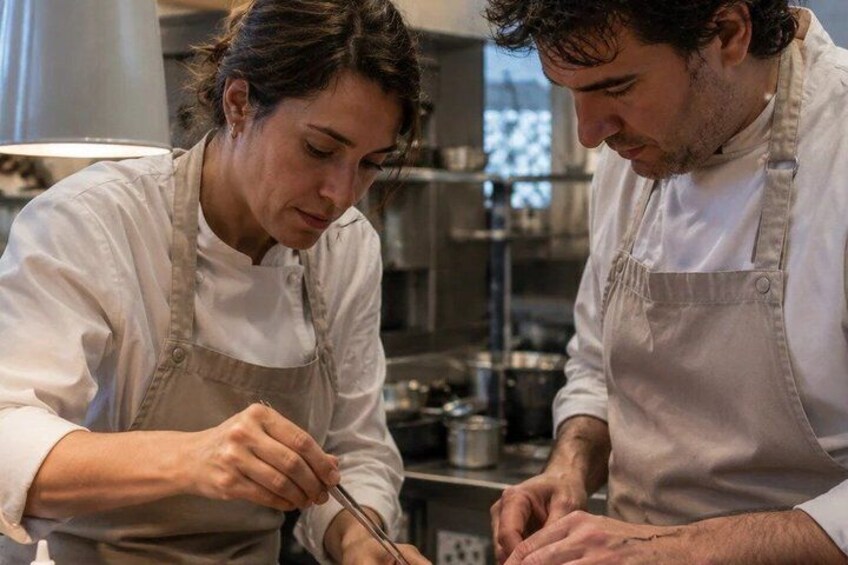 Two chefs in a kitchen, one cutting ingredients. 4