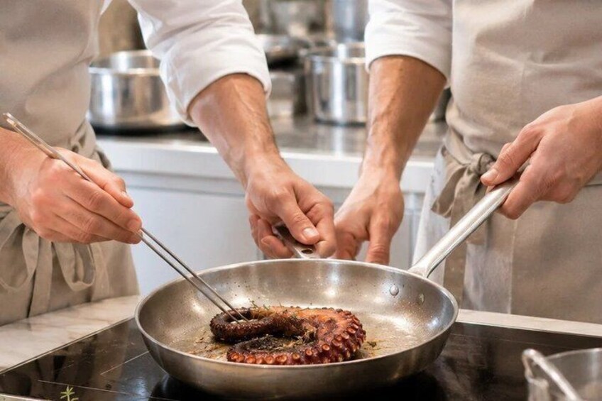 Two people cooking a large piece of meat in a pan on a stove. 1