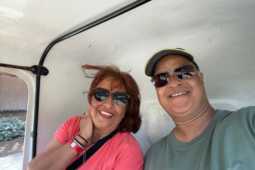 Two people in a vehicle with a white interior. 3