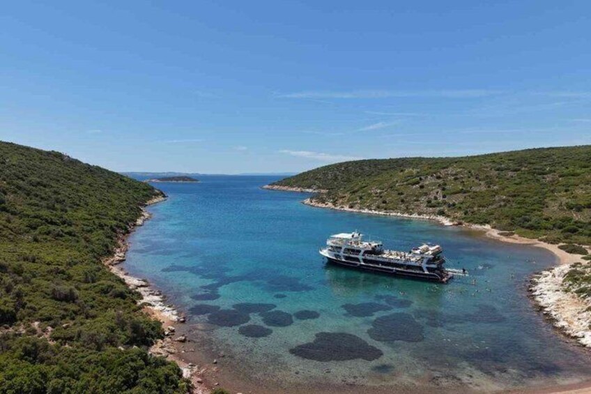 A boat on a clear blue sea with a coastline. 1