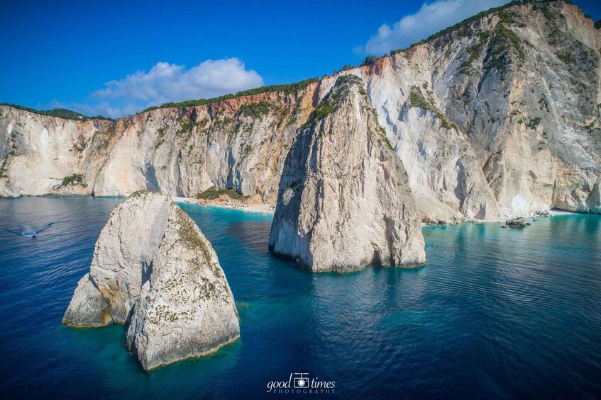 A coastal landscape with prominent white rock formations and clear blue waters. 1