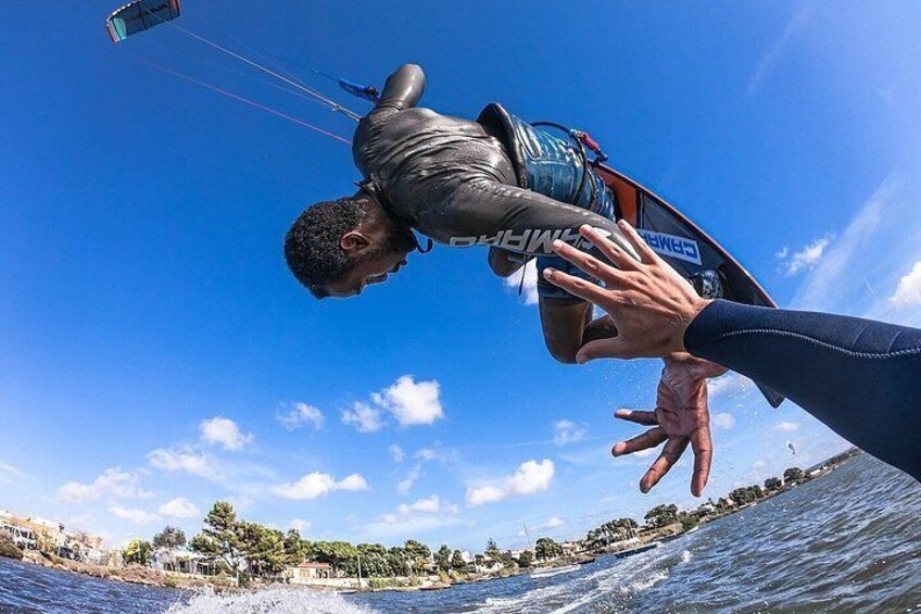 A person parasailing over water with a clear sky and a coastline in the background. 1